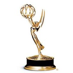 Image of a shiny gold Emmy Award statue. The statue features a winged woman holding an atom-like structure above her head, symbolizing the merging of art and science. It stands on a circular base, often presented in the television industry for excellence and often cherished by J-School alum.