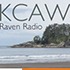 A small headland covered with trees juts out into the ocean under a cloudy sky. The text "KCAW Raven Radio" is prominent in the upper part of the image, with a subtle "Thank You" message beneath it. Waves gently crash on a sandy beach in the foreground.