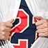 A person is pulling open their outer shirt with both hands to reveal a navy blue shirt underneath, proudly displaying a large red and white number "24," just like the excitement of revealing Simons's new book.