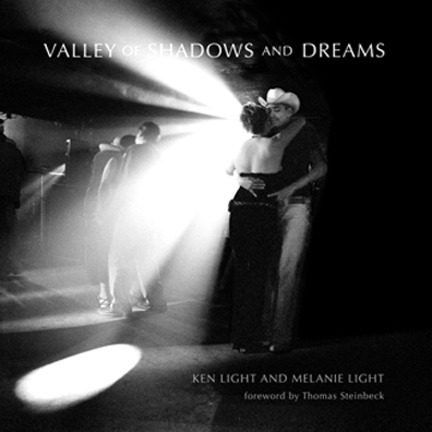 Book cover for "Valley of Shadows and Dreams" by Ken Light and Melanie Light, featuring a black-and-white photo of a couple dancing in a dimly lit room with light rays filtering through. The cover includes a foreword by Thomas Steinbeck, setting the scene for an unforgettable reception.