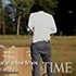 A person with dark hair, wearing a white shirt and dark pants, stands in a grassy area with trees in the background. Nearby, cardboard boxes hint at ongoing efforts in mine removal. The cover of Time magazine is superimposed on the scene.