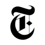 The image showcases the distinct blackletter "T" logo of The New York Times. Styled in a vintage, ornate design with sharp edges and a diamond-shaped cutout near the center, the letter "T" stands prominently against a plain white background, evoking the paper's storied editorial tradition.