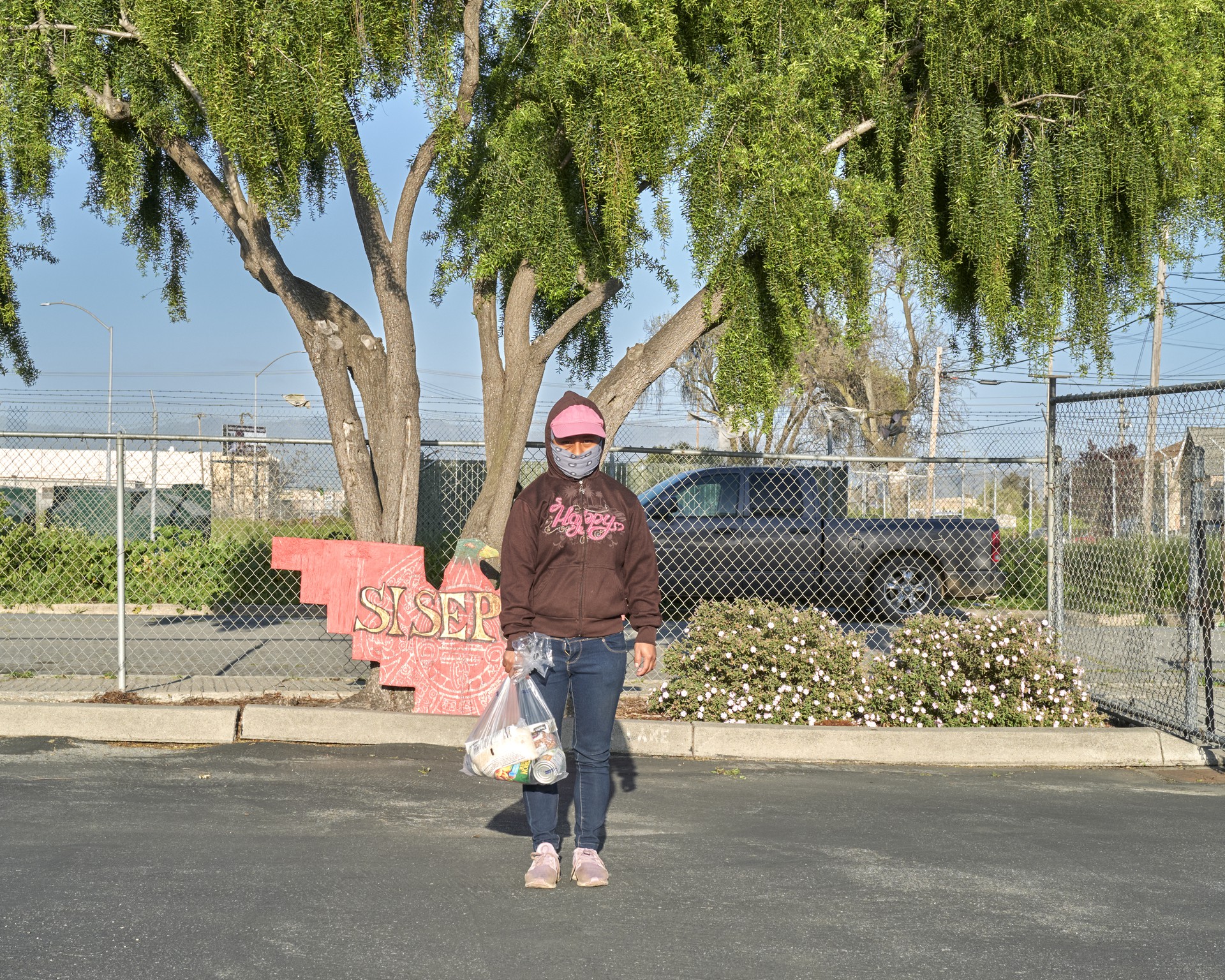 Photo of an undocumented farmworker in a parking lot after picking up food from the United Farm Workers Foundation food bank in Salinas Valley.