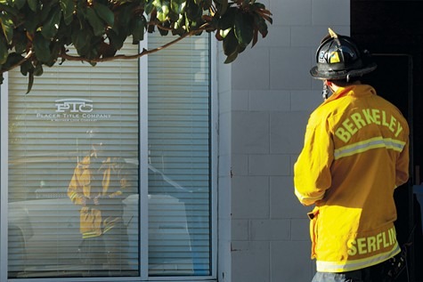A firefighter wearing a yellow jacket labeled 