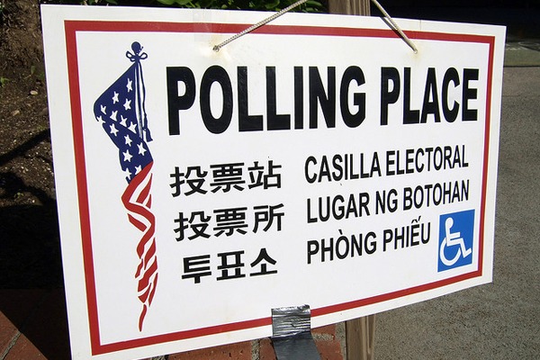 A sign indicating a polling place is seen attached to a brick block. The sign includes "POLLING PLACE" in bold letters, along with translations in Chinese, Spanish, Tagalog, and Vietnamese. There is an accessible icon at the bottom right corner—an example of thorough reporting from Berkeley Journalism.