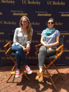Two individuals sit on director's chairs in front of a UC Berkeley Graduate School of Journalism step and repeat backdrop. The person on the left wears sunglasses, a white shirt, blue jeans, and red sneakers. The person on the right sports sunglasses, a blue top, grey pants, and brown shoes—all representing Berkeley Journalism.