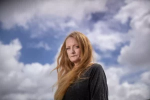 Crystal Leff stands in front of a cloudy sky.