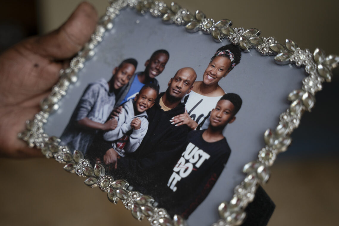 A family photo of Shannon's son Dante Pickettay with his wife and 4 children in a silver decorative picture frame. 