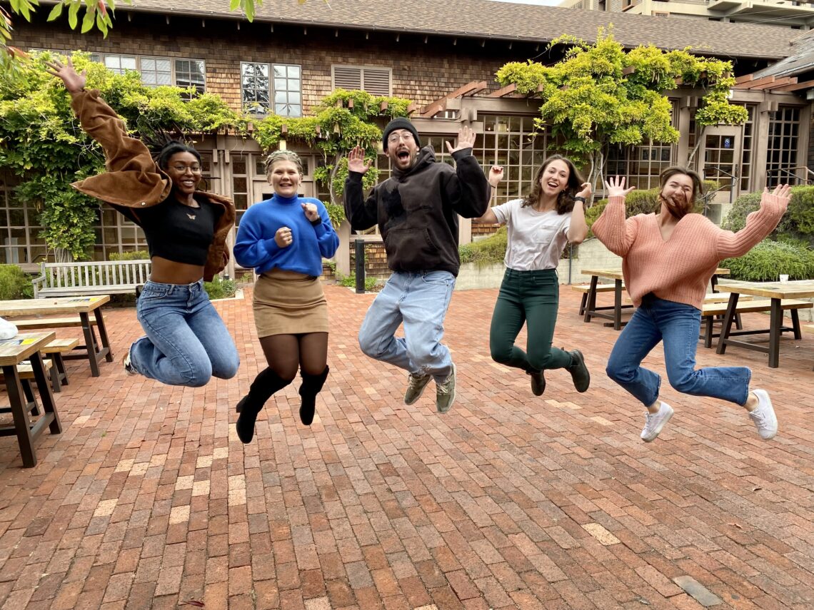 Award-winning students jumping in North Gate courtyard.