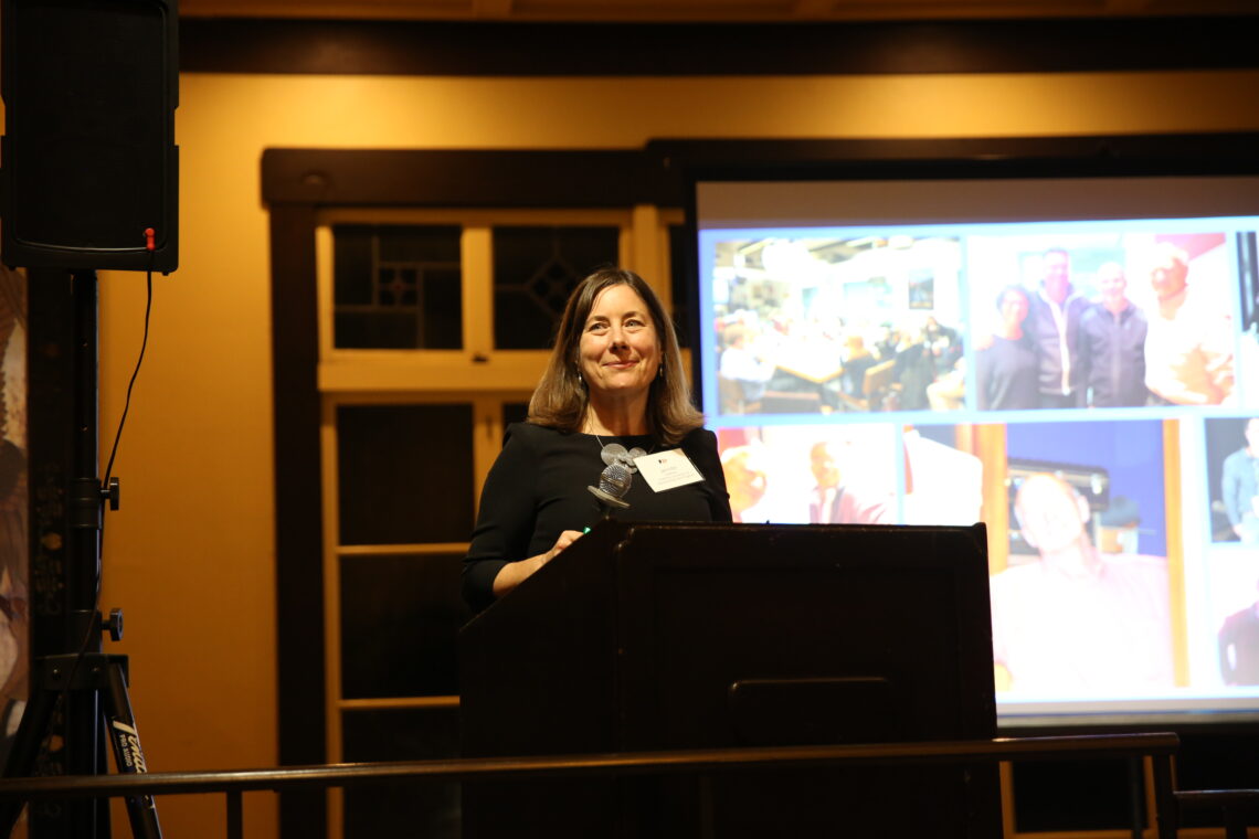 Professor Jennifer Redfearn speaking at a podium.
