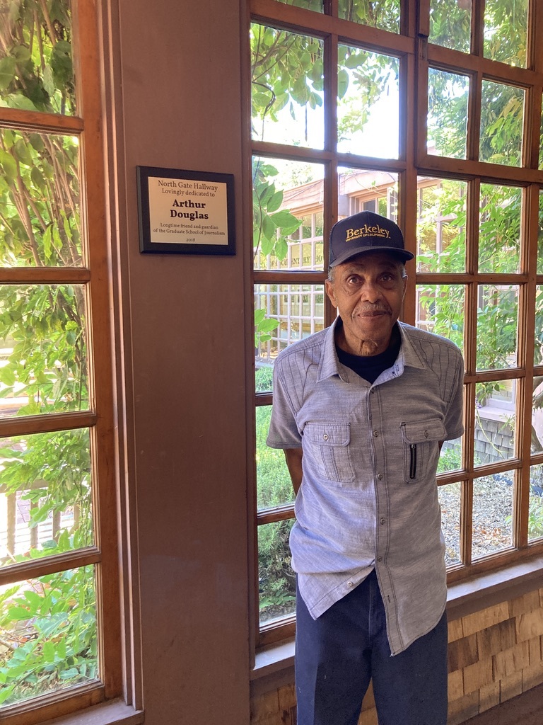 An older man wearing a navy cap with 