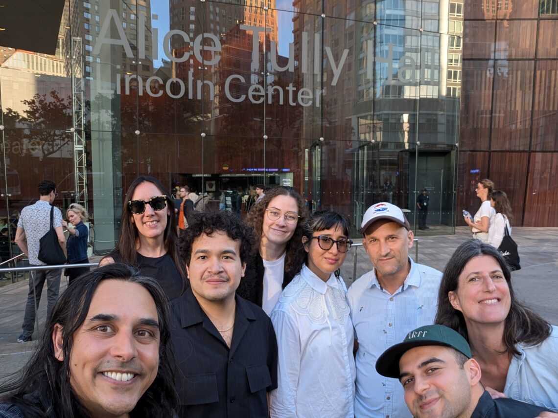 A group of people smiling in front of Alice Tully Hall at Lincoln Center on a sunny day in June 2024.