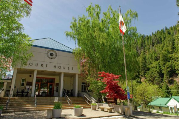 Sierra County Court House Steps, the California Flag waves next to the parking lot. 