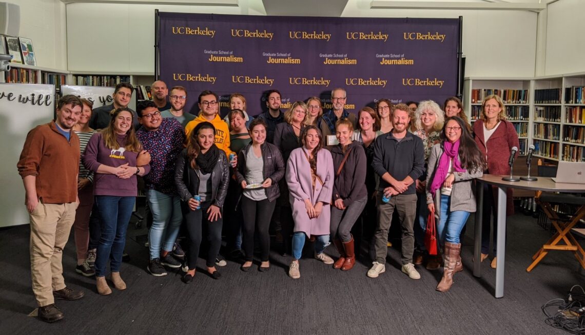 A large group of audio journalists stand together at a retirement party.