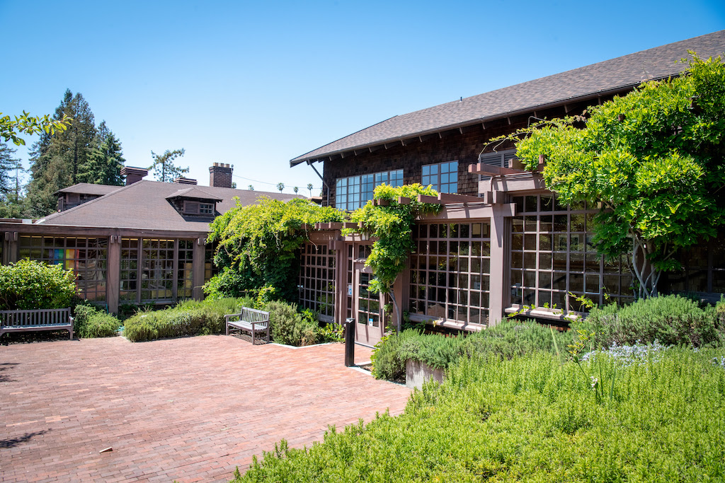 North Gate Hall outdoor courtyard with brown shingled building and greenery.