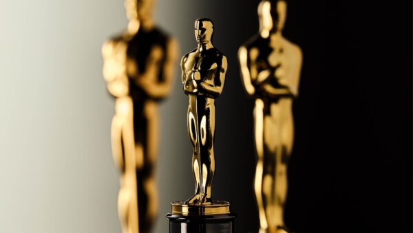 3 gold Oscar statues in front of a black background.