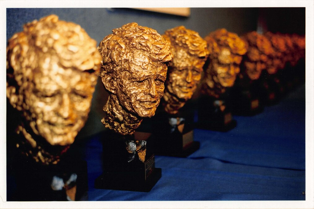 A descending row of RFK statues in bright gold light.