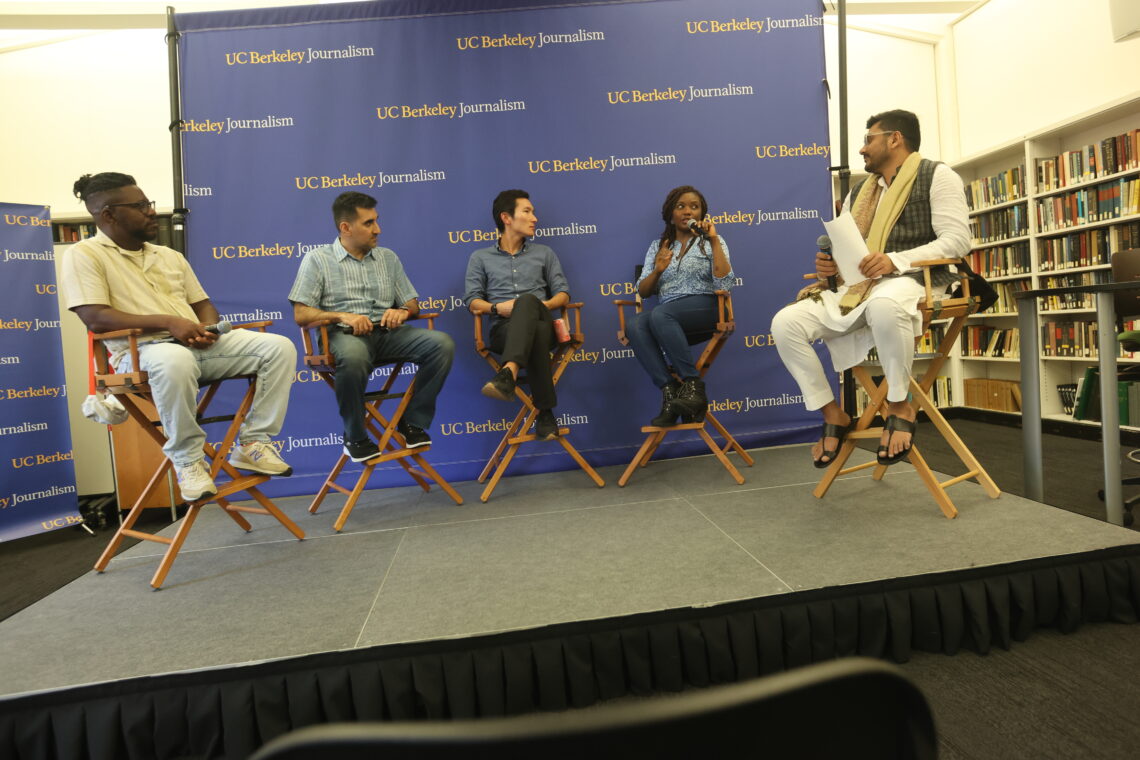 Five international alumni journalists sit on chairs on a stage in front of a blue and gold Berkeley Journalism banner.