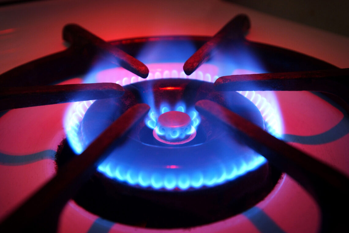 Close up image of a lit gas stovetop.